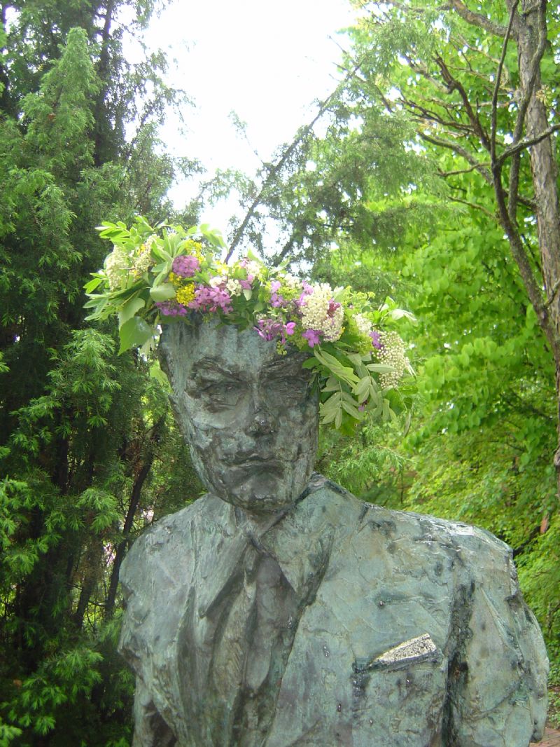 Jan Fridegård i brons med blomsterkrans i håret.